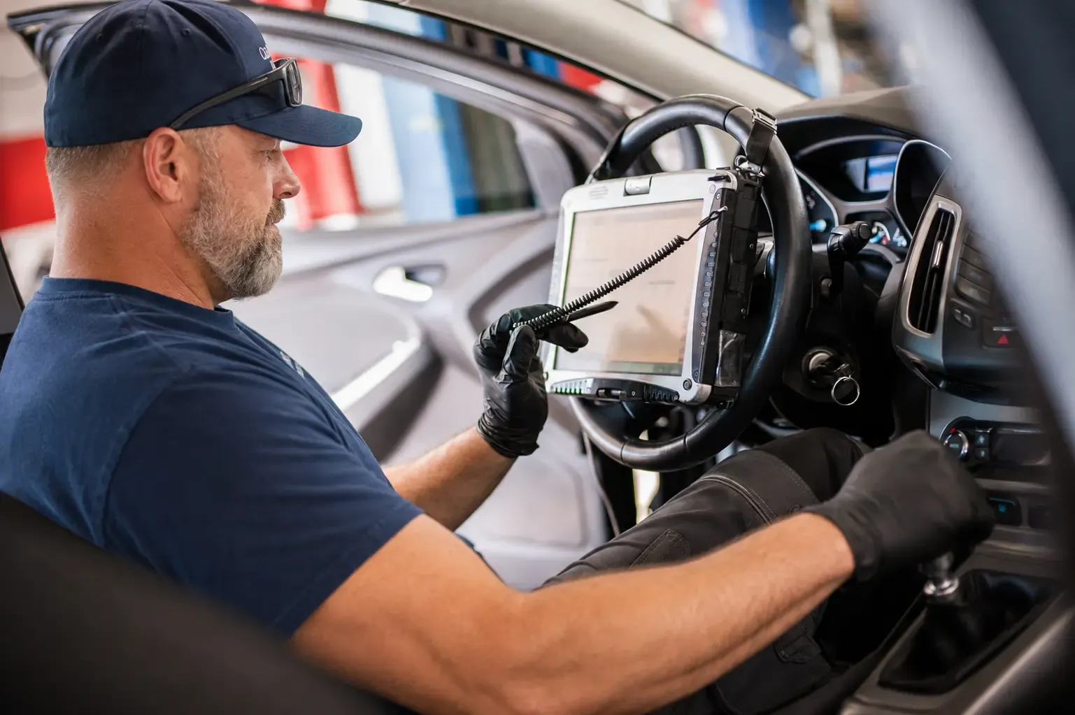 Technician using a rugged tablet during ADAS calibration