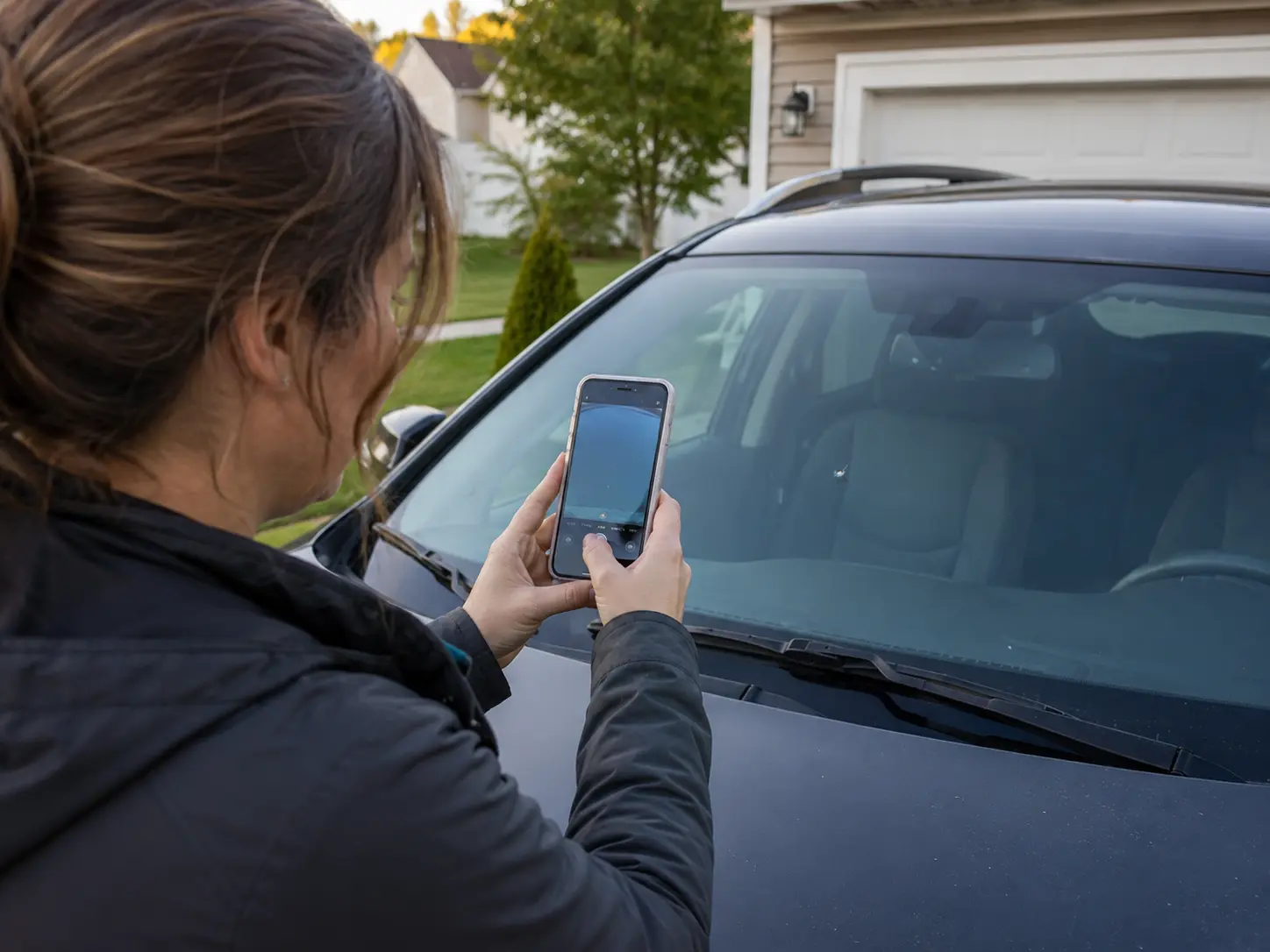 Customer photographing a rock chip on her windshield to send damage details to Clear Image Auto Glass.