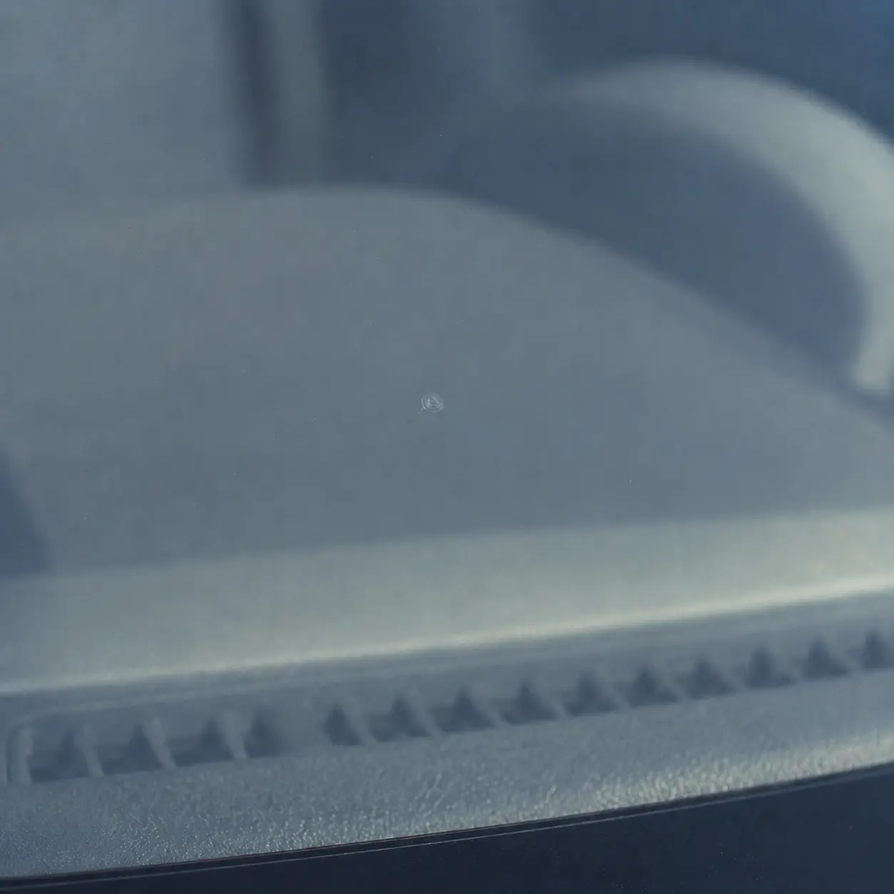 Close-up of the same windshield rock chip after professional repair